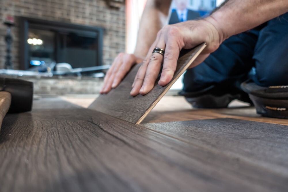 A man installing laminate wood floor