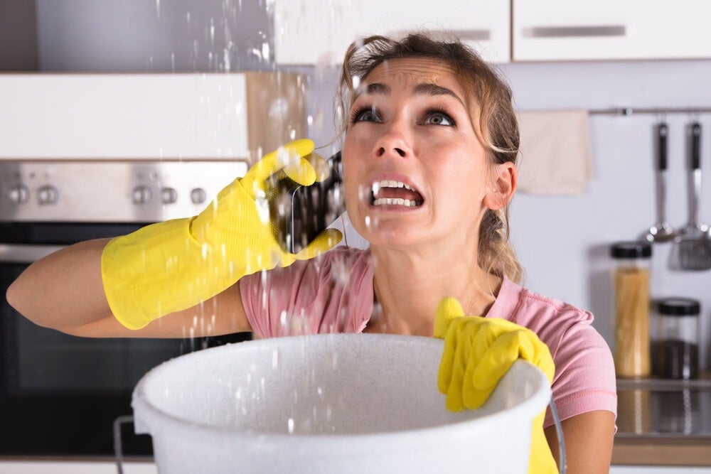 A woman stood under a leaking roof