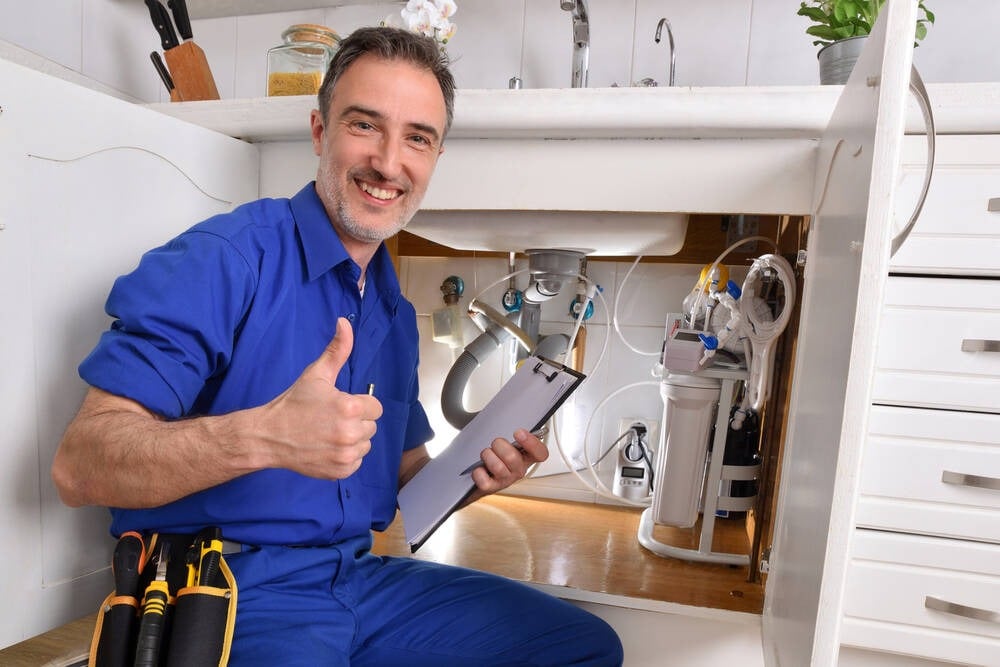 A plumber fixing under the sink