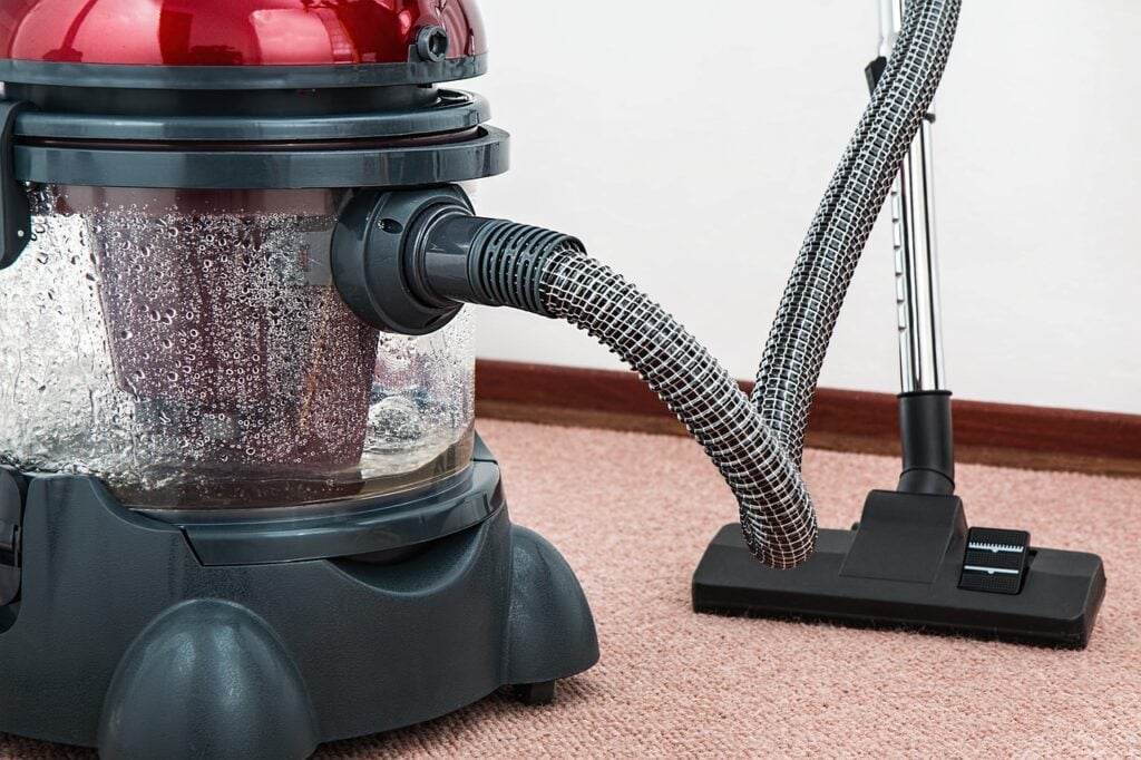 A vaccum cleaner on a red carpet