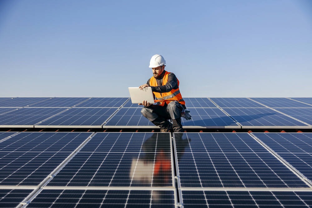 A tradesmen inspecting solar panels