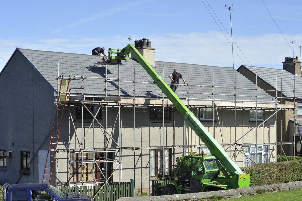 A house with scaffolding and a crane outside